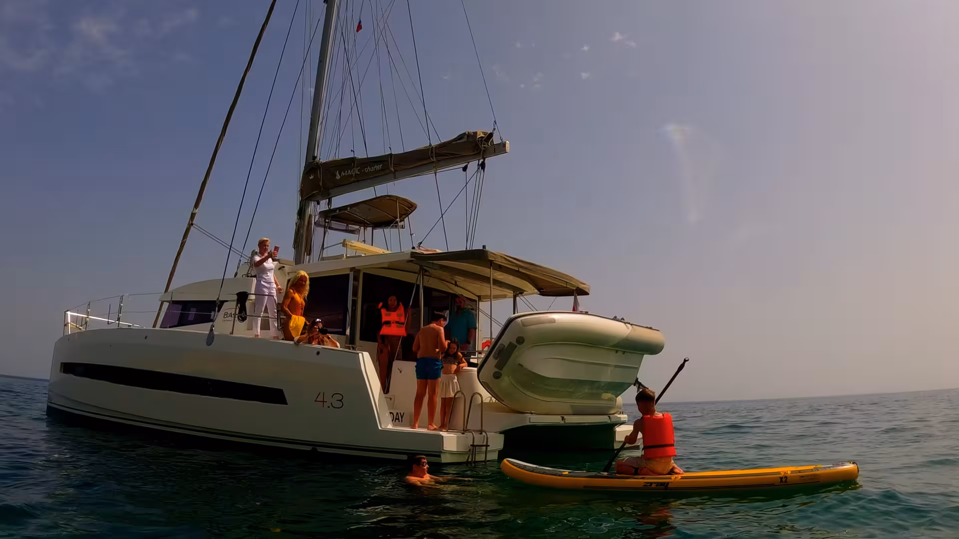 White catamaran sailing by Ponta da Piedade cliffs in Lagos on a full-day Algarve cruise with sea caves