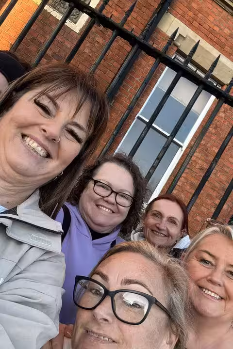 Group of five smiling women posing for selfie on Belfast ghost walking tour street