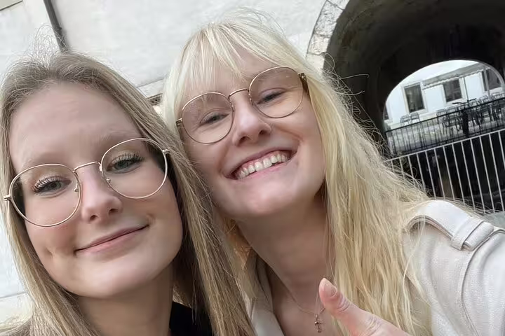 Two travelers smiling by an Aarau old town archway on a self-guided scavenger hunt and sights walking tour