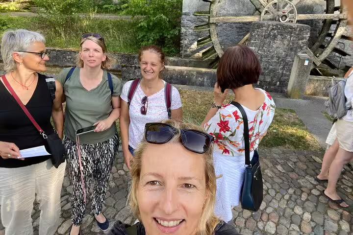 Friends pause by Aarau’s historic waterwheel during a self-guided scavenger hunt sightseeing tour