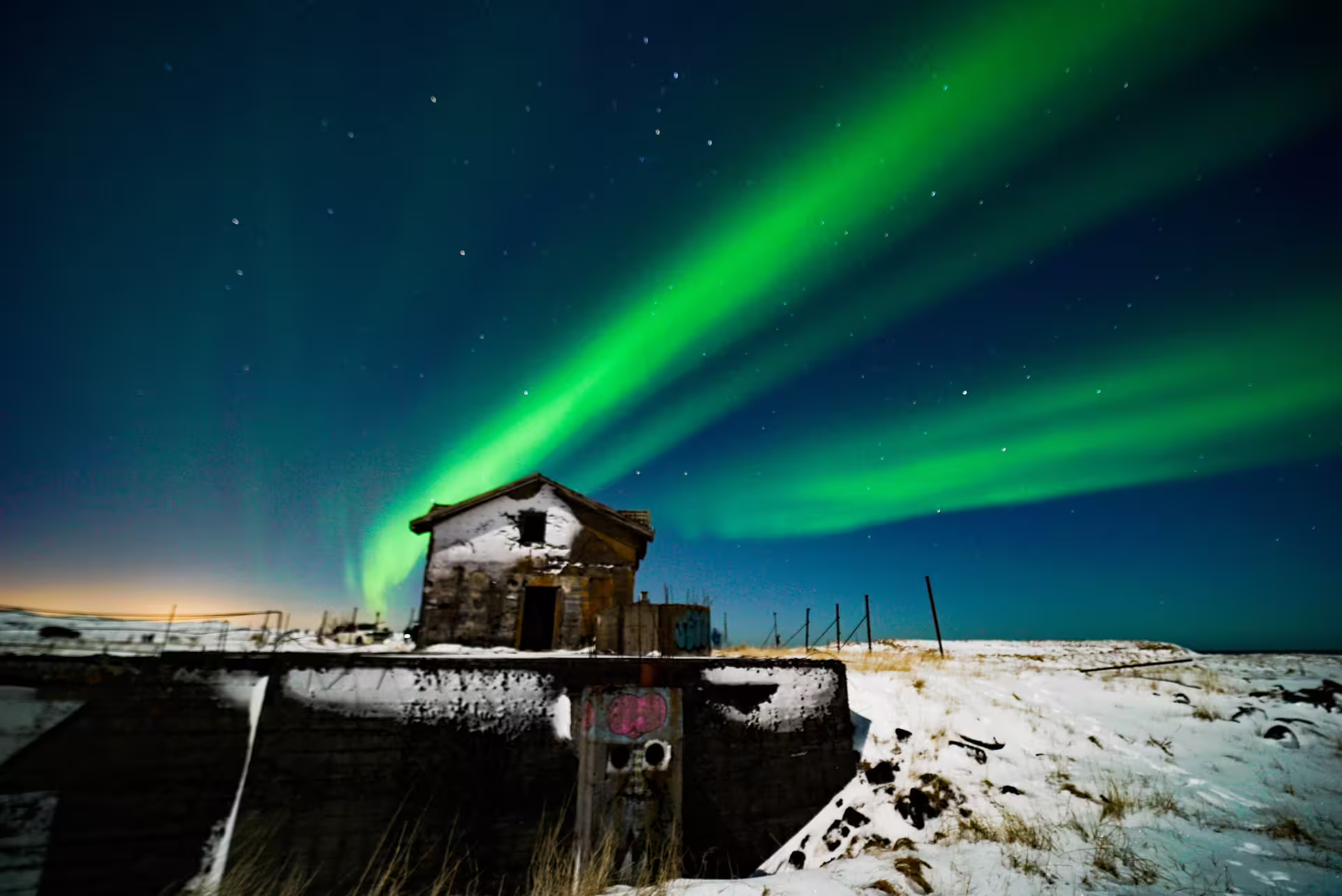 Abandoned house with northern lights over 