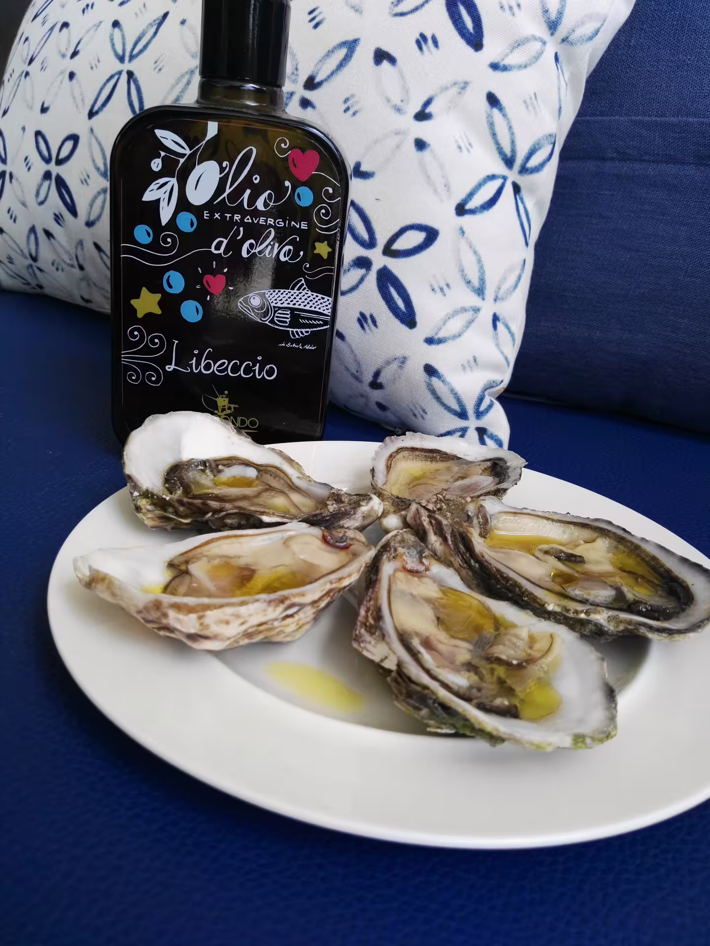 Abruzzo extra virgin olive oil bottle with fresh oysters drizzled in EVOO, gourmet tasting pairing on tour