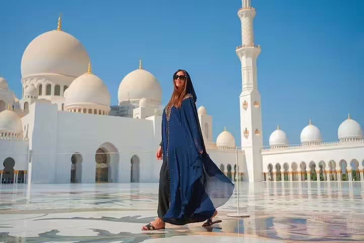 Woman in traditional attire exploring Sheikh Zayed Grand Mosque during Abu Dhabi city tour from Dubai in 4x4 vehicle.