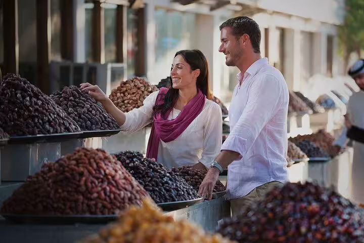 Tourists exploring a vibrant date market in Abu Dhabi on a 4x4 city tour from Dubai.