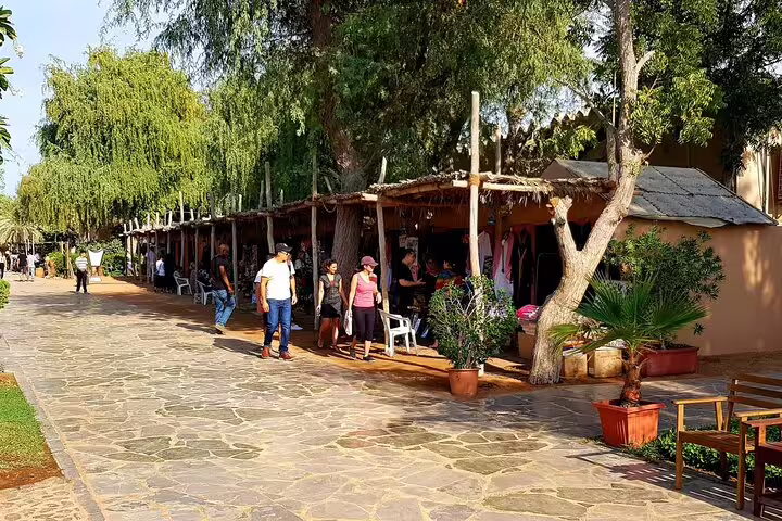 Tourists browse traditional market stalls at the UAE Heritage Village in Abu Dhabi on a 4x4 tour from Dubai.