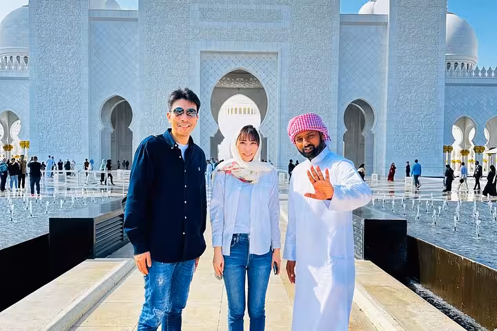 Travelers at Sheikh Zayed Grand Mosque on Abu Dhabi layover tour with seamless airport pickup and drop-off