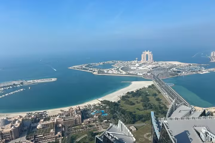 Panoramic Abu Dhabi city tour view from Etihad Tower, overlooking Corniche beaches and Emirates Palace skyline
