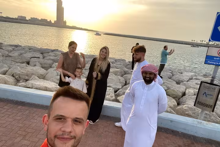 Tourists and local guide enjoying Abu Dhabi waterfront sunset on full-day Grand Mosque Emirates Palace tour