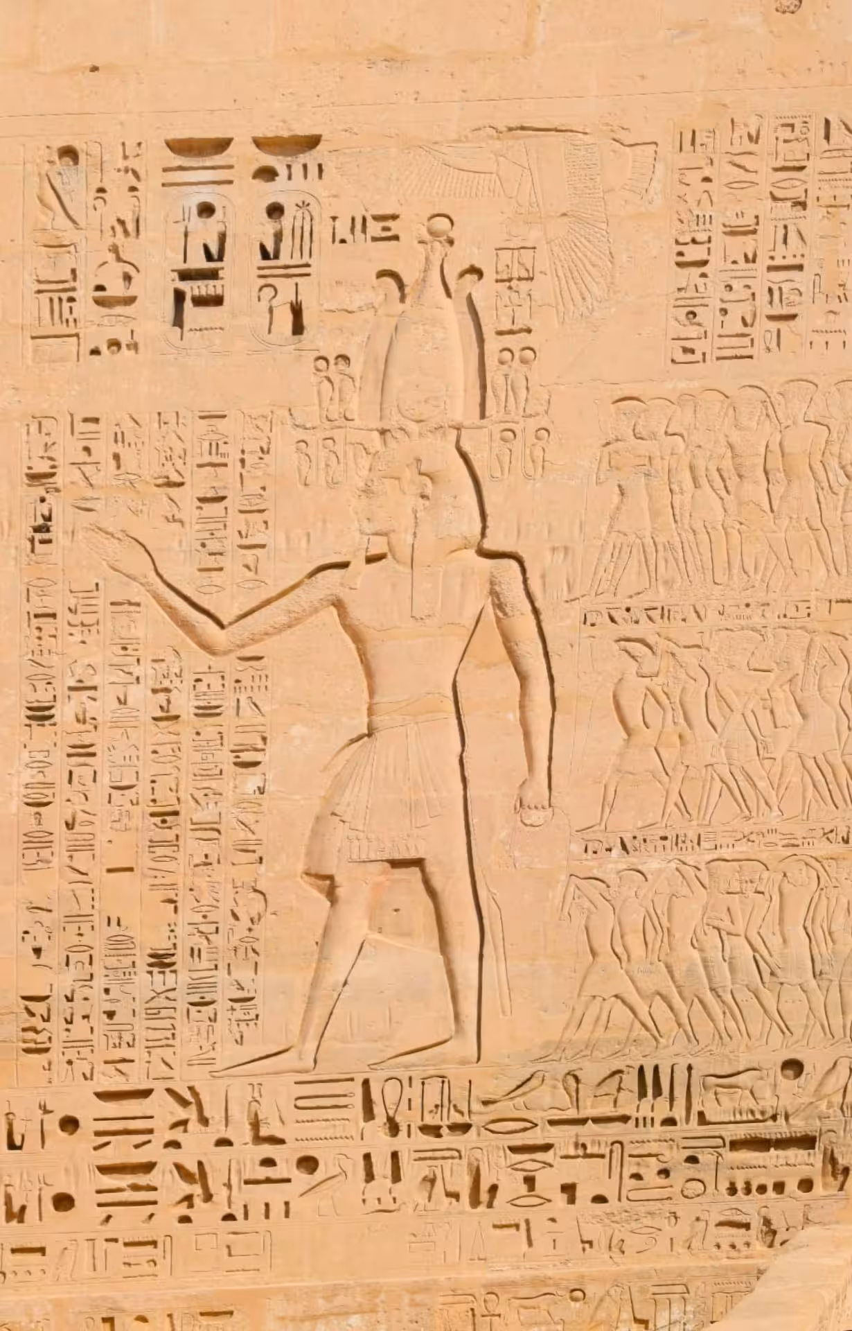 Ancient Egyptian hieroglyphic carvings and pharaoh relief sculpture on sandstone temple wall at Abu Simbel