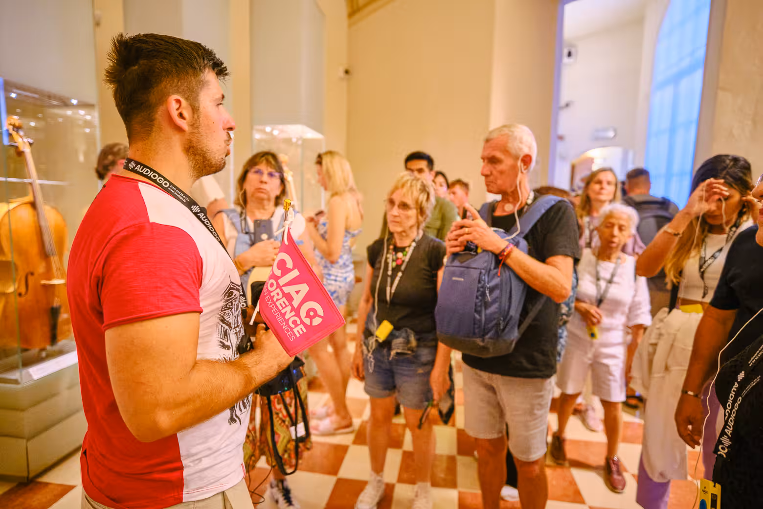 Guide explaining exhibits to attentive visitors on a guided tour at Accademia Gallery in Florence.