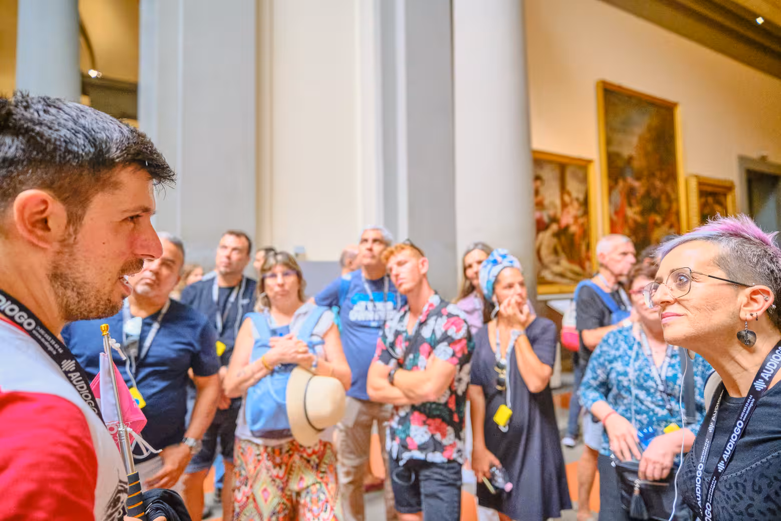 Tour guide engaging visitors inside Florence's Accademia Gallery during a skip-the-line guided tour.
