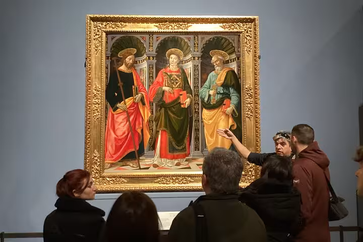 Visitors admire a religious masterpiece during the Accademia Gallery small-group tour in Florence.