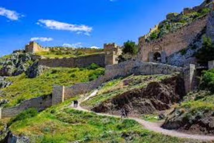 Scenic Acrocorinth castle walls above green hillside, Ancient Corinth half-day tour from Athens