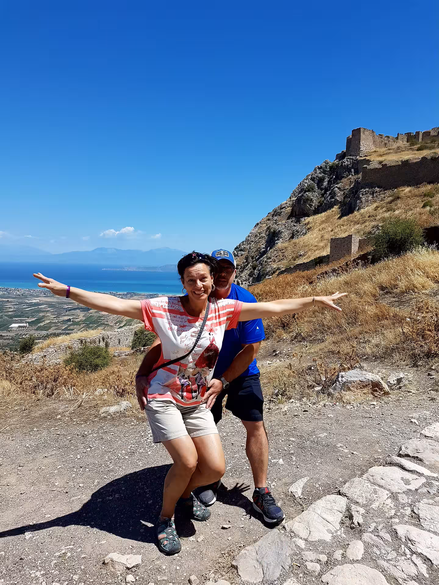 Travelers posing at Acrocorinth viewpoint over the Gulf of Corinth on a private tour from Athens
