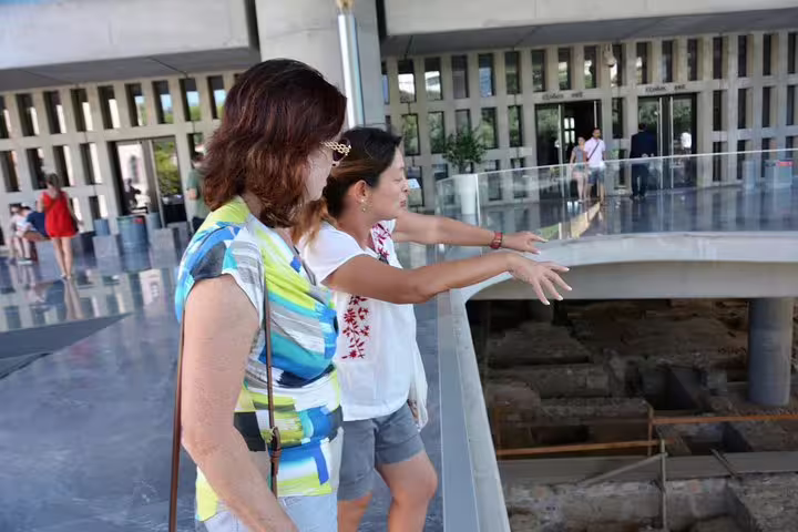 Visitors with guide overlooking excavations inside the New Acropolis Museum on Viator exclusive tour