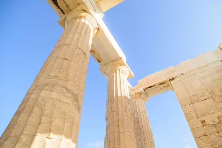 Upward view of ancient Acropolis marble columns in Athens, featured on a French-guided walking tour
