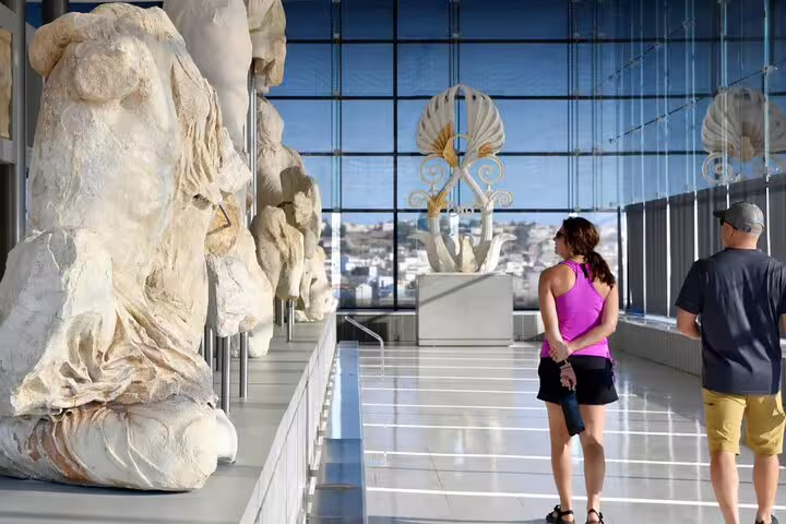 Visitors viewing Acropolis Museum sculptures with city views, optional stop on Athens Parthenon tour