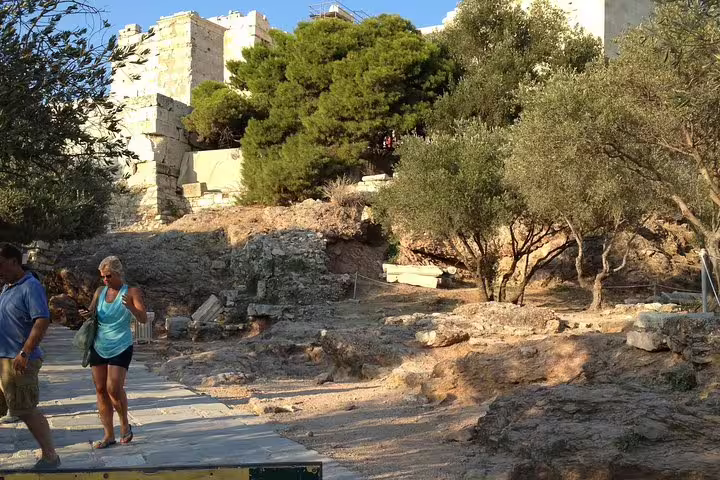 Scenic Acropolis hillside path near Parthenon on Athens walking tour, with olive trees and ancient stones