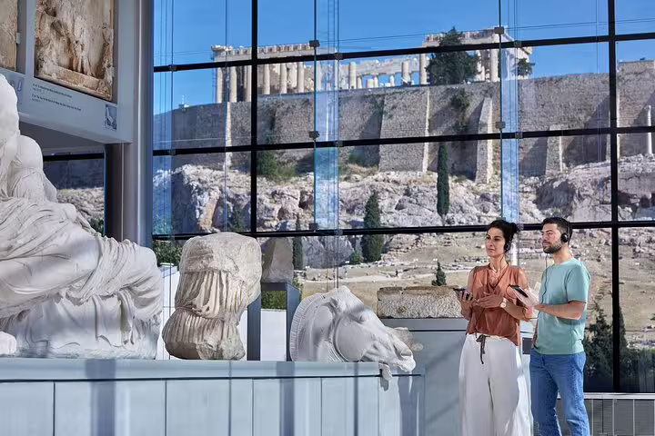 Visitors viewing Acropolis Museum sculptures with Acropolis hill outside, Parthenon walking tour Athens