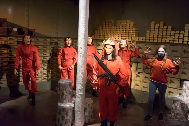 Actors in red heist costumes inside museum exhibit, Sucesos Locales + Catedral tour exploring Barcelona stories