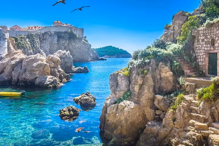 Rocky Adriatic cove near Dubrovnik Old Town walls, crystal-clear water on Budapest to Dubrovnik route