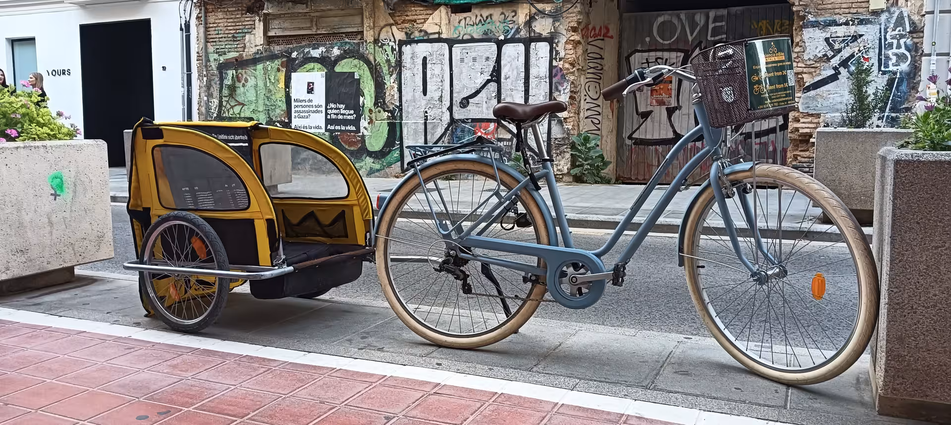 Comfortable adult city bike rental with front basket and kid trailer attachment, ideal for family city cycling