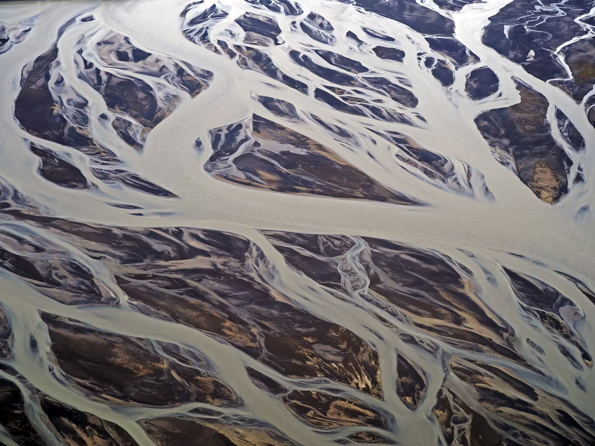 Aerial view of braided glacial river channels and sediment patterns in South Iceland