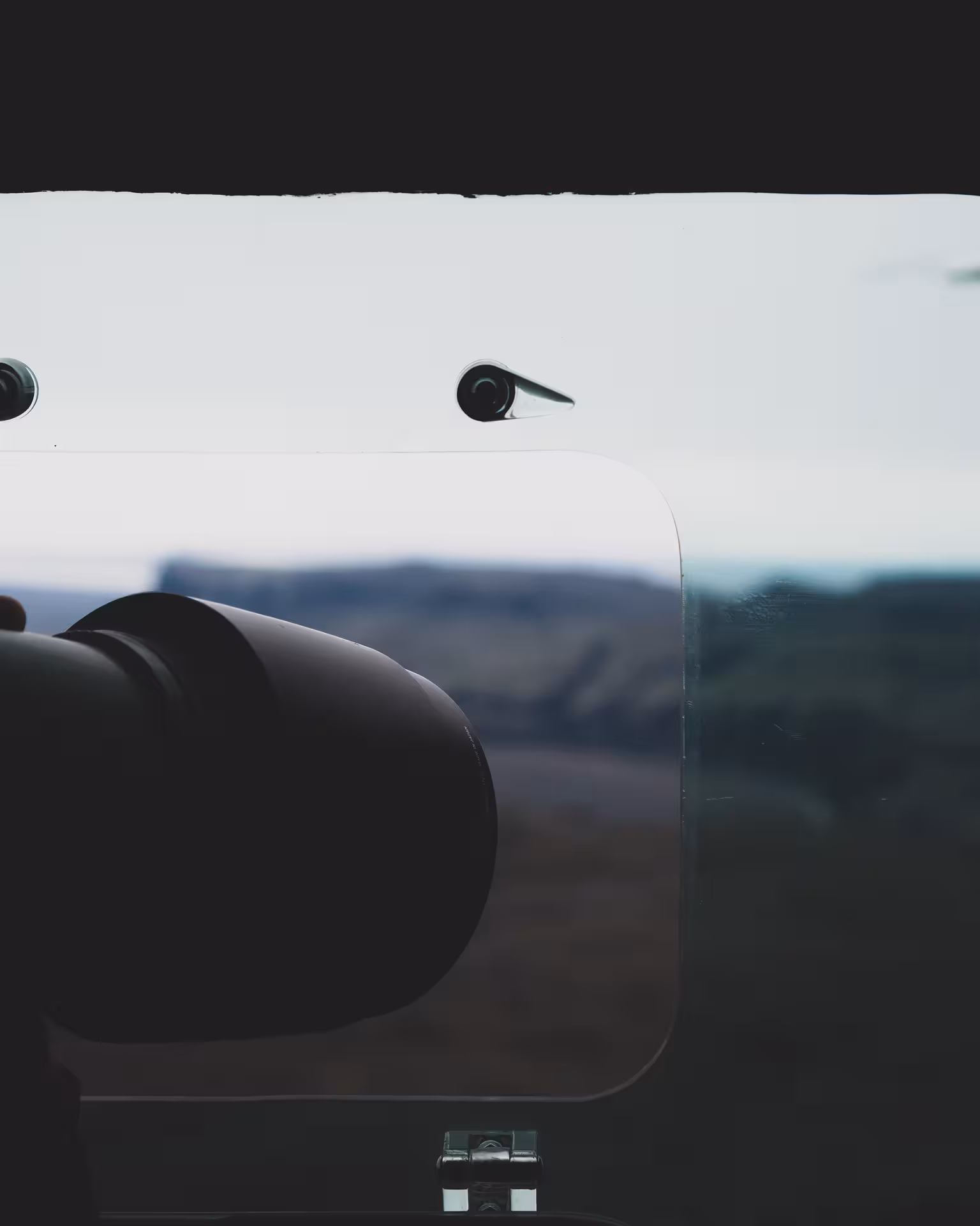 Aerial photography camera mounted on aircraft with glacial landscape visible through window