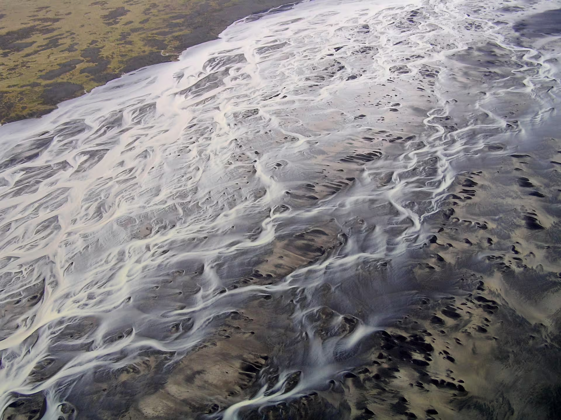 Aerial view of braided glacial river channels and black sand plains in South Iceland