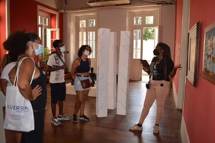 Visitors engage with Afro-Brazilian art guided tour in a vibrant Rio gallery in Little Africa.