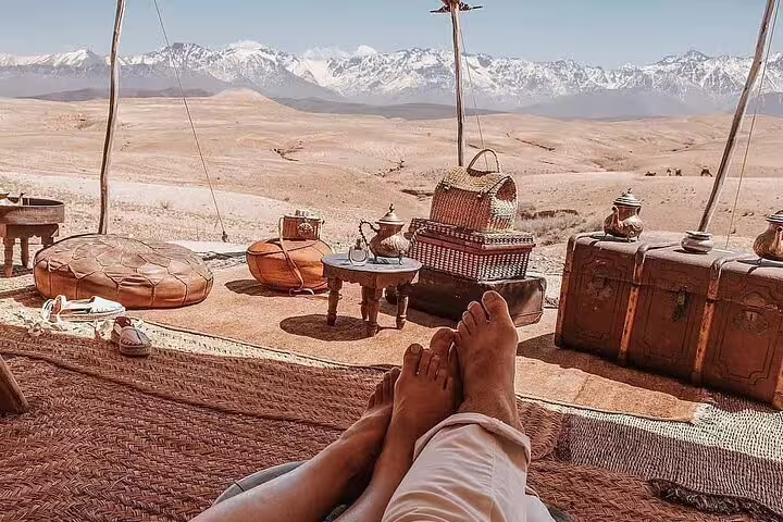 Agafay Desert camp lounge with tea set and Atlas Mountains view, perfect sunset camel ride from Marrakech