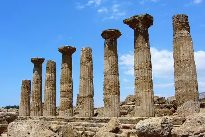Ruined stone columns of an ancient Greek temple in Agrigento’s Valley of the Temples under blue skies on a Palermo private excursion