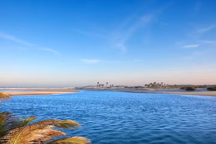Águas Belas Tour panorama of calm lagoon, golden dunes and distant palms, perfect for a relaxing beach day