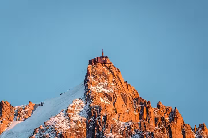 Aiguille du Midi mountain peak with observation station glowing at sunset, Chamonix Alps