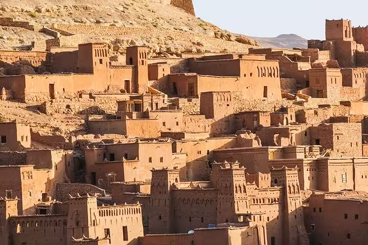 Sunset illuminating the historic mud-brick architecture of Ait Benhaddou, a highlight on the Fes to Marrakech tour.