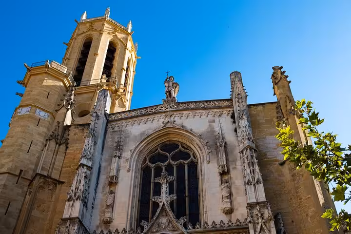 Close-up of the intricate architecture of Aix-en-Provence Cathedral against a clear blue sky.
