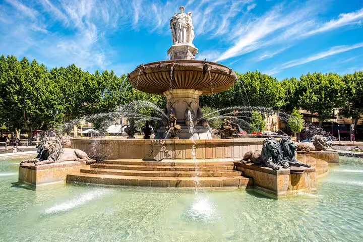 Ornate multi-tiered fountain with lion sculptures and classical statue in Aix-en-Provence town square