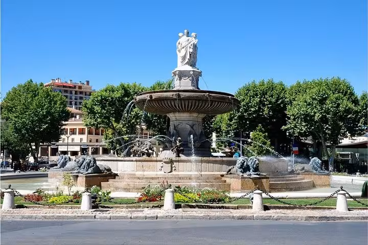 Ornate tiered fountain with lion sculptures and statue in Aix-en-Provence town square