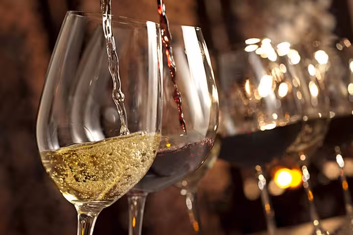 Close-up of red and white wine being poured into glasses during a wine tasting experience in Aix En Provence.