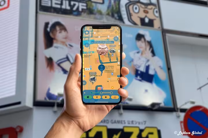 Akihabara anime walking tour mobile app navigation map displayed on phone with idol posters in background Japan