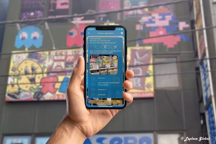 Interactive gaming quiz on mobile app held up against colorful retro arcade mural in Akihabara Electric Town Tokyo