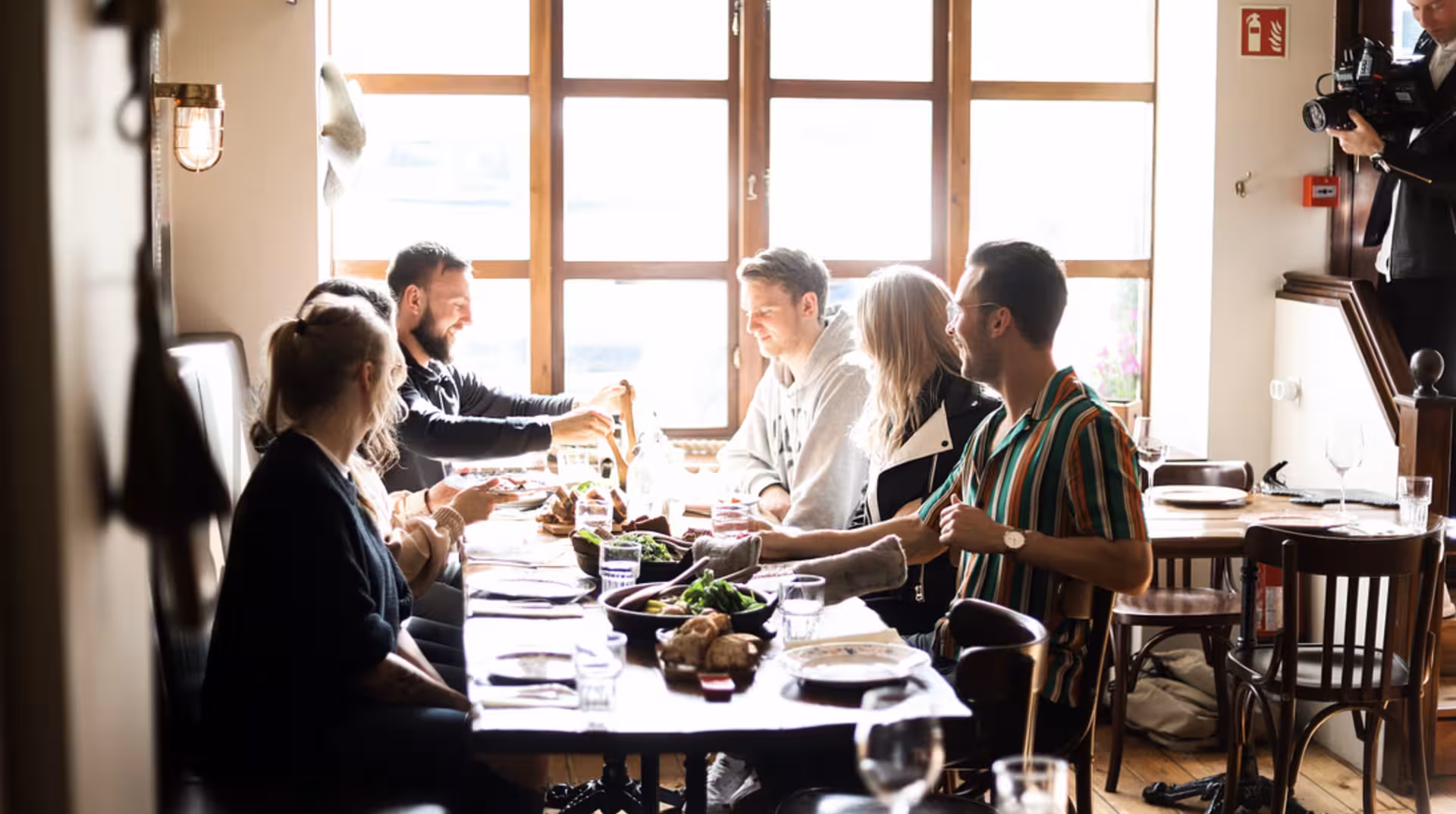 Group of friends sharing a meal at a cozy restaurant table in Akureyri, Iceland