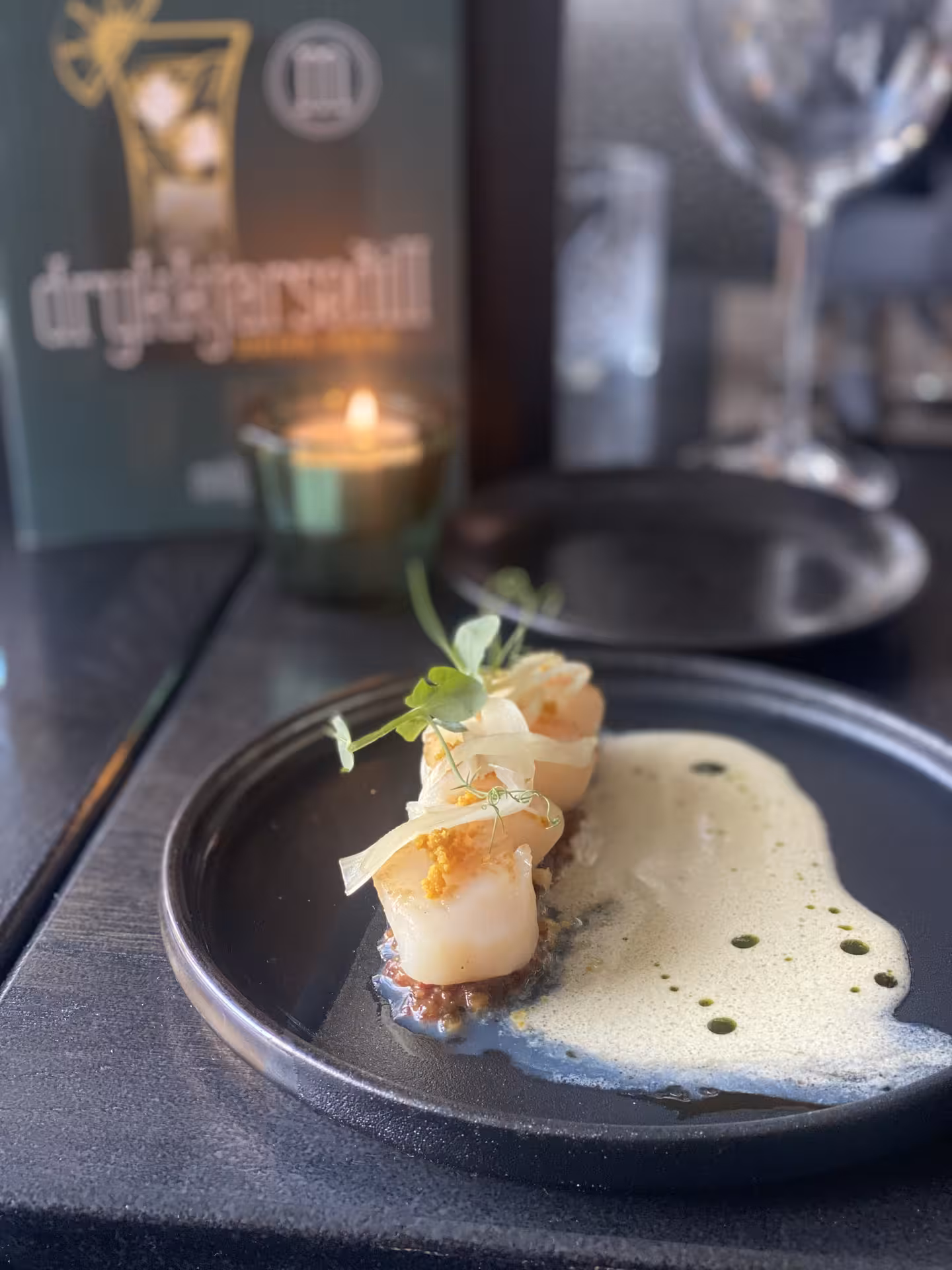 Plated seared scallops with foam sauce and microgreens at an Akureyri restaurant