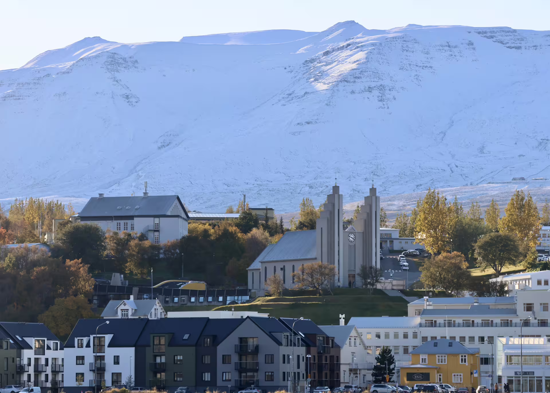 Akureyri town with church and snow-capped mountains in Eyjafjordur fjord, Iceland