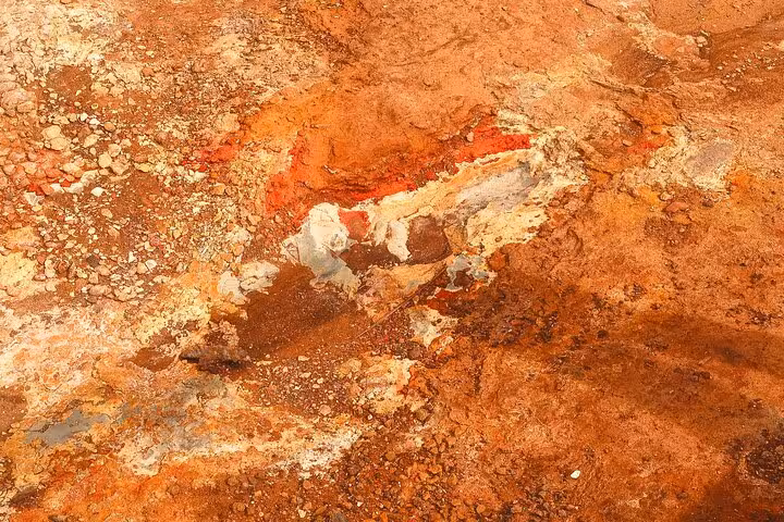 Vibrant red and orange mineral-rich volcanic terrain with white deposits near Akureyri Iceland