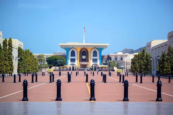 View of Al Alam Palace with its colorful facade and ceremonial courtyard, a key sightseeing stop on a half-day Muscat city tour