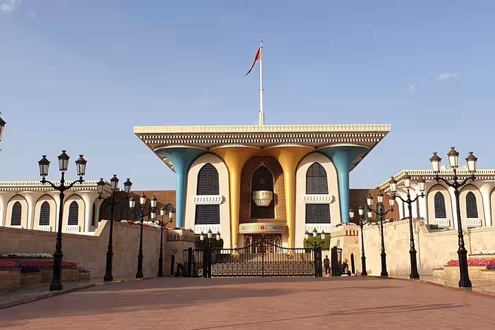 Al Alam Royal Palace colorful facade with golden arches and Omani flag on a private Muscat sightseeing tour