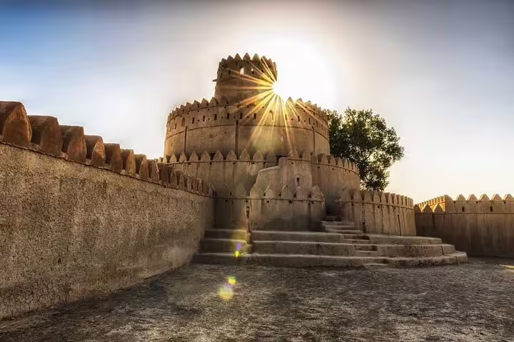 Historic Al Jahili Fort in Al Ain at sunrise, showcasing Emirati heritage on a private garden city tour.