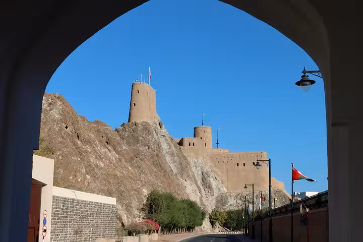 Historic Al Mirani Fort perched on rocky hill viewed through arch on private Muscat city sightseeing tour