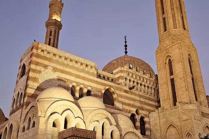 Al Mustafa Mosque facade with domes and minarets at dusk, featured on Sharm El Sheikh guided city tour